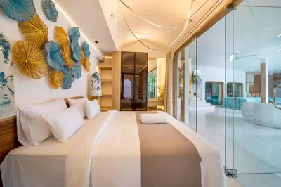 a bedroom with a large bed with a glass wall at Magic Mango Villa Huge Projector bubble bath unique design in Canggu