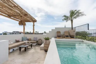 a patio with a pool and a couch and a table at The Revery Bali in Canggu