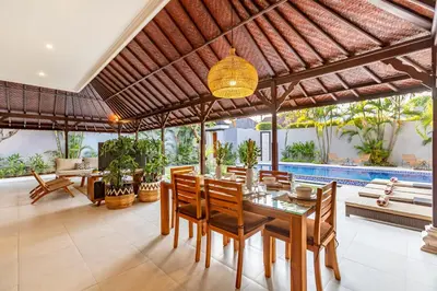 a dining room with a table and chairs and a pool at Viona 3 Villa - 3 BDR villa, walk to the beach in Seminyak