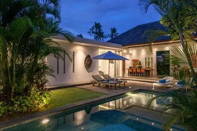 a villa with a swimming pool in front of a house at Villa Cempaka Ungu - Tranquil & Chic Pool 4-Bedroom Villa In The Heart Of Seminyak in Seminyak