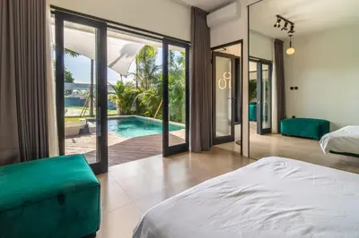 a bedroom with a bed and a swimming pool at Rice field View with Sauna Projector and Jacuzzi Unique design in Canggu