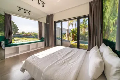 a bedroom with a large bed and large windows at Rice field View with Sauna Projector and Jacuzzi Unique design in Canggu
