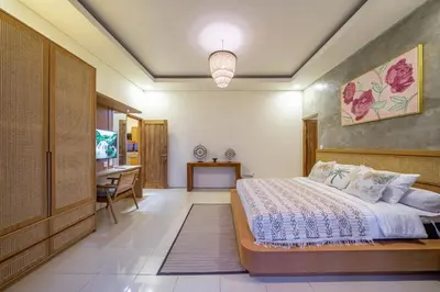 a bedroom with a bed and a desk at Kalya Villa by RPM in Seminyak