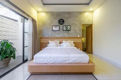 a bedroom with a large bed with white sheets at Kalya Villa by RPM in Seminyak