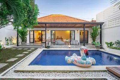 a swimming pool in a backyard with a house at Kalya Villa by RPM in Seminyak