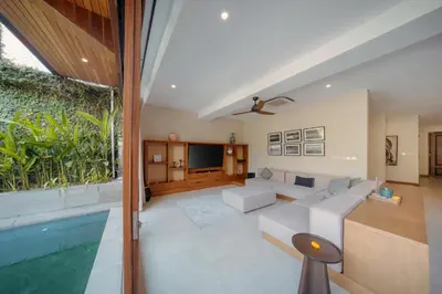a living room with a white couch and a pool at Kolila Villa Seminyak by Ini Vie Hospitality in Seminyak