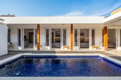 a swimming pool in front of a house at Lumturi House - Centrally Located in Kerobokan