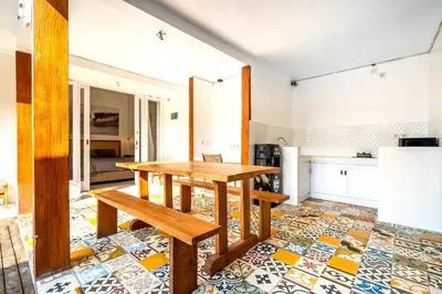 a dining room with a table and a kitchen at Lumturi House - Centrally Located in Kerobokan