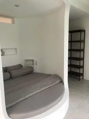 a bed in a room with a white wall at Villa Lina, Nusa Dua Benoa in Nusa Dua