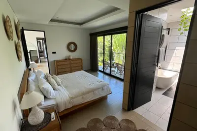 a bedroom with a bed and a bathroom with a tub at Admire Villa - a luxury private villa with Pool in Legian