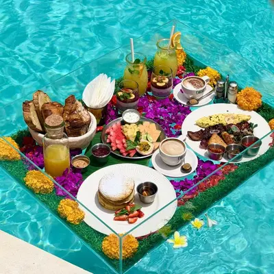 a table with food and drinks in a swimming pool at Admire Villa - a luxury private villa with Pool in Legian