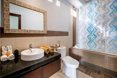 a bathroom with a sink and a toilet and a mirror at Villa Sebelas Legian in Seminyak