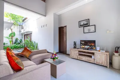 a living room with a couch and a flat screen tv at Villa Sebelas Legian in Seminyak