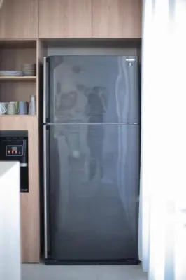 a refrigerator in a kitchen with a persons reflection in it at Casa Z - Seminyak 3BR Villa with Private Pool in Seminyak