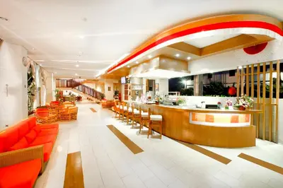 a restaurant with orange furniture and a bar at Euphoria Hotel in Legian