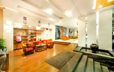 a large living room with a table and chairs at Euphoria Hotel in Legian