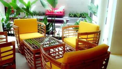 a group of chairs and tables in a room with plants at Euphoria Hotel in Legian