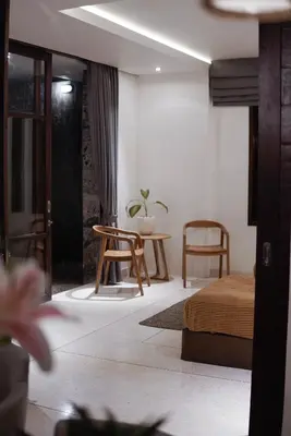a room with a bed and a table and chairs at Villa Duadewi 4BR in the Heart of Seminyak by Santi Management in Seminyak
