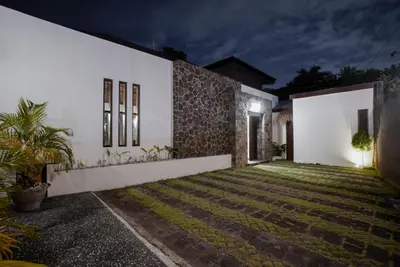 a villa with a courtyard at night at Villa Duadewi 4BR in the Heart of Seminyak by Santi Management in Seminyak