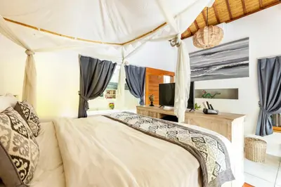 a bedroom with a canopy bed with a television at Luxurious Double King Villa w/Pool & WiFi+ Carpark in Seminyak
