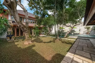 an exterior view of a house with a yard with trees at Balinese Luxury Amisha Villa: 4BR in Seminyak in Seminyak