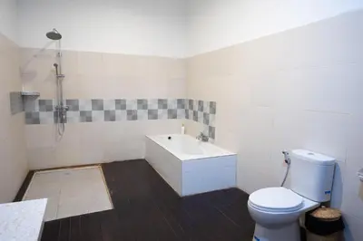 a bathroom with a white toilet and a sink at Nossa Casa Villa in Seminyak