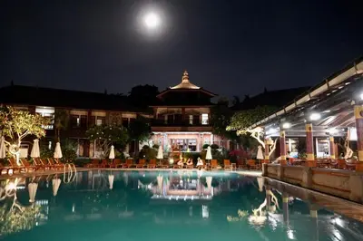 a pool in front of a building at night at Galayanee’s Resort Apartment in Seminyak