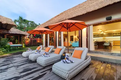 a group of chairs and umbrellas on a patio at Villa Mahkota Seminyak in Seminyak
