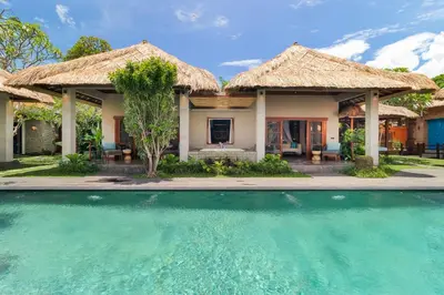 a house with a swimming pool in front of it at Villa Mahkota Seminyak in Seminyak