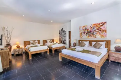 a hotel room with two beds and a couch at Enclose living 5Br Villa Center of Seminyak Near Beach in Seminyak