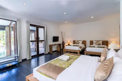 a large bedroom with two beds and a television at Enclose living 5Br Villa Center of Seminyak Near Beach in Seminyak