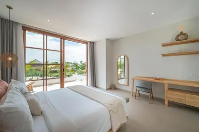 a bedroom with a bed and a desk and a window at Villa LouLou Bali - Brand New Tropical 3BR Villa Next to Canggu in Canggu