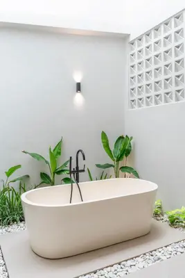 a white bath tub in a bathroom with plants at Villa LouLou Bali - Brand New Tropical 3BR Villa Next to Canggu in Canggu