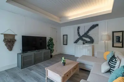 a living room with a couch and a tv at Blanc Mediterranean: 3BR in Central Canggu in Canggu