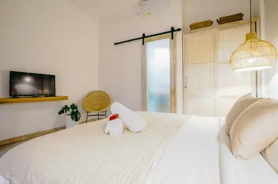 a bedroom with a white bed with a stuffed animal on it at Villa Aarka - Chic Balinese Bohemian Retreat in Seminyak in Seminyak