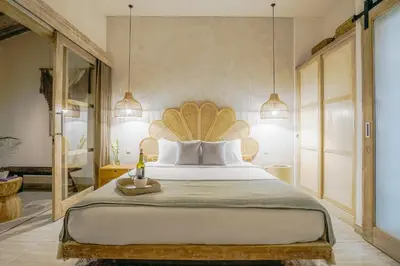 a bedroom with a large bed with a wooden headboard at Villa Aarka - Chic Balinese Bohemian Retreat in Seminyak in Seminyak