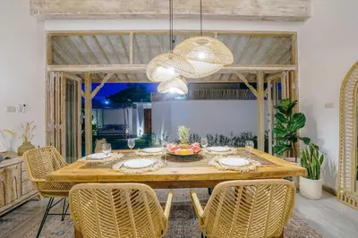 a dining room with a wooden table and chairs at Villa Aarka - Chic Balinese Bohemian Retreat in Seminyak in Seminyak