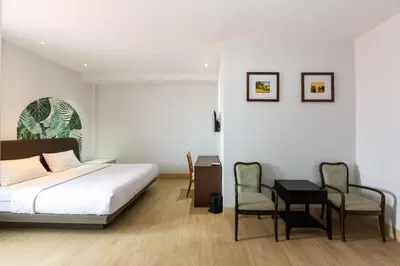 a bedroom with a bed and a table and chairs at Cove Matahari Senja in Denpasar
