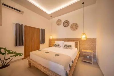 a bedroom with a large bed and a table at Villa James Seminyak in Seminyak