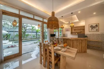 a kitchen and dining room with a table and a pool at Villa James Seminyak in Seminyak