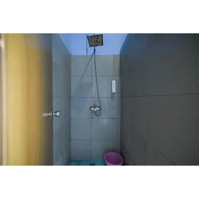 a bathroom with a shower with a pink toilet at Bunk Bed Bali near Sanur Mitra RedDoorz in Pesanggaran