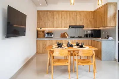 a kitchen with a wooden table and chairs at Sundaze 2 - Canggu Paradise with Pool and Kitchen Brand NEW in Kerobokan