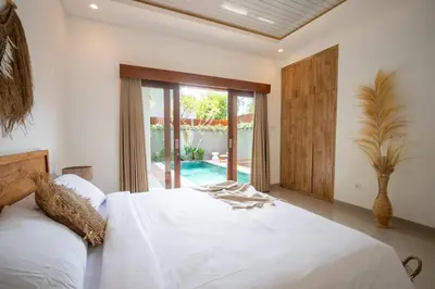 a bedroom with a white bed and a sliding glass door at Sundaze 2 - Canggu Paradise with Pool and Kitchen Brand NEW in Kerobokan