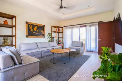 a living room with a couch and a table at Villa Palm Suites Bali in Seminyak