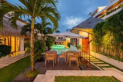 a patio with a table and chairs and a pool at Berawa Village Apartment by Betterplace in Canggu