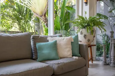 a couch sitting in front of a large window at Villa Sunsara 2 - Spacious 4-Bedroom Haven next to Berawa Beach in Canggu