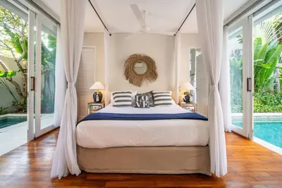 a bedroom with a bed and a swimming pool at Villa Sunsara 2 - Spacious 4-Bedroom Haven next to Berawa Beach in Canggu
