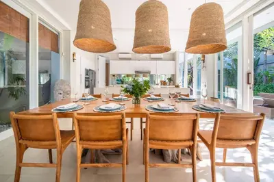 a dining room with a wooden table and chairs at Villa Sunsara 2 - Spacious 4-Bedroom Haven next to Berawa Beach in Canggu