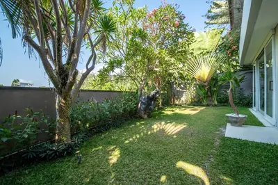 a garden with a cat sitting in the grass at Villa Sunsara 2 - Spacious 4-Bedroom Haven next to Berawa Beach in Canggu