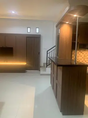 a large room with a counter and a staircase at Cahaya Residence The Guest House in Kuta